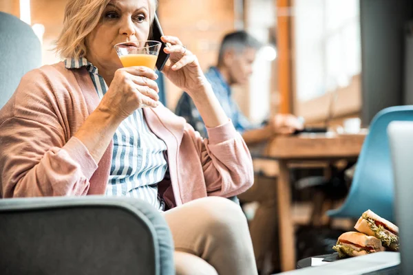 Vacker mogen kvinna som håller i ett glas juice — Stockfoto