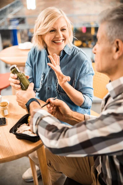 Feliz madura hombre y mujer hablando adout comida —  Fotos de Stock