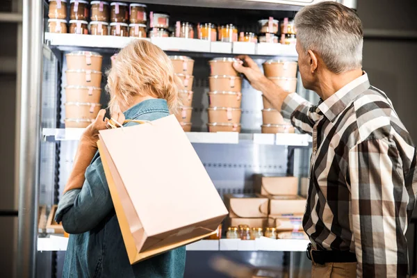 Couple d'âge mûr regardant des produits sur des étagères dans un magasin — Photo