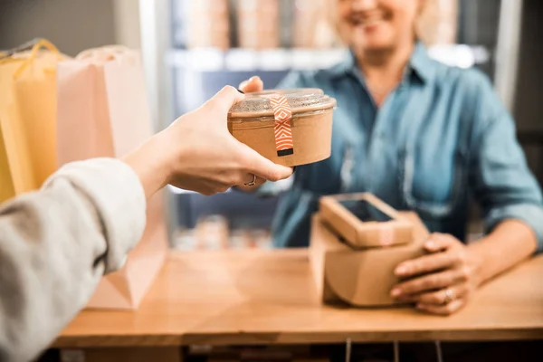 Mujer comprador está dando compra a cajero — Foto de Stock