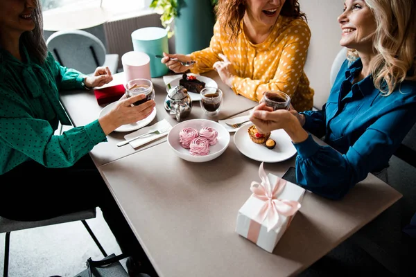 Vidám hölgyek teáznak és süteményt esznek. — Stock Fotó
