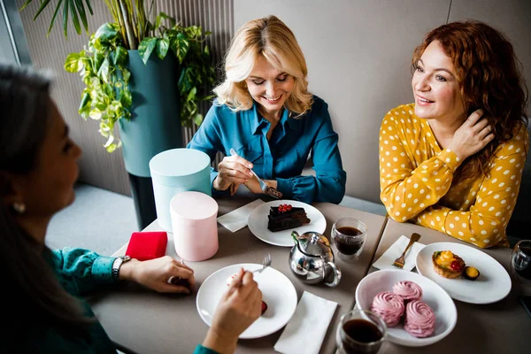 Fröhliche Damen genießen Kuchen und plaudern im Café — Stockfoto