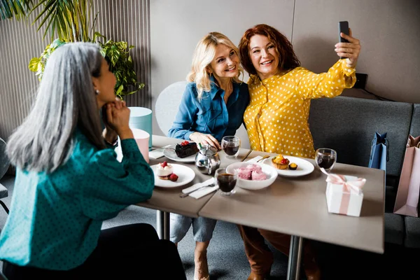 Schöne fröhliche Frauen machen Selfie im Café — Stockfoto