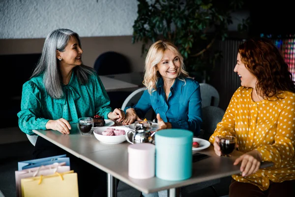 Három elbűvölő nő beszélgetett és nevetett a kávézóban. — Stock Fotó