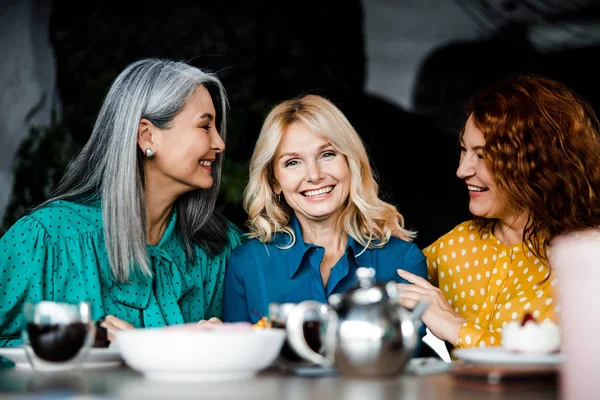 Три очаровательные дамы сидят за столом в кафе — стоковое фото