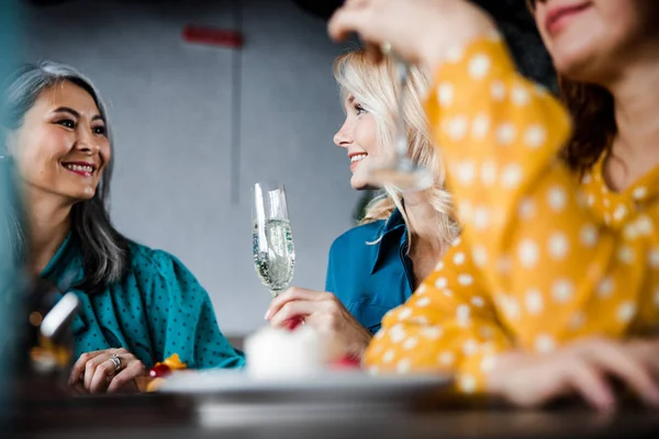 Gyönyörű hölgyek beszélgetnek és mosolyognak a kávézóban — Stock Fotó