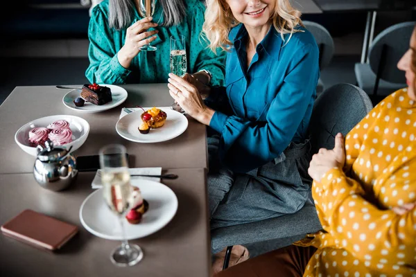 Freundinnen genießen Desserts und Getränke im Café — Stockfoto