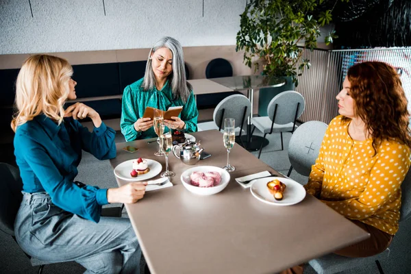 Drei schöne Frau sitzt am Tisch im Café — Stockfoto