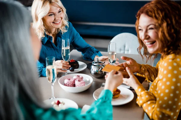 Веселі дами сидять за столом у кафе — стокове фото