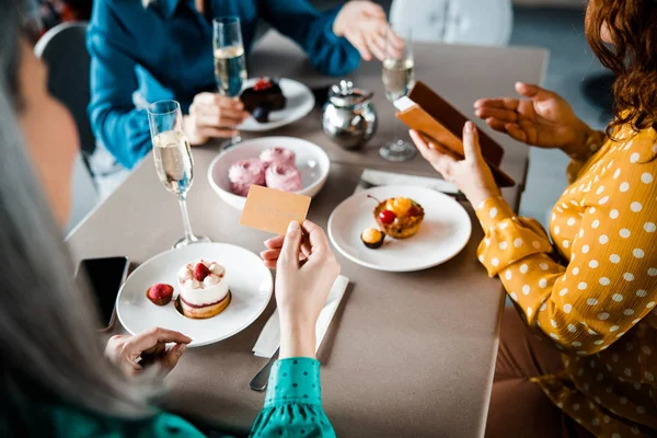 Tre damer betalar för beställning i caféet — Stockfoto