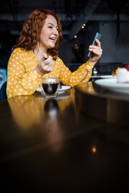 Cafe 'de modern akıllı telefon kullanan çekici bir kadın.