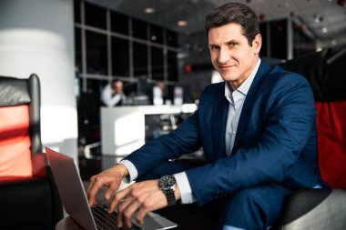 Laptop üzerinde çalışan yakışıklı orta yaşlı girişimci.