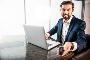 Elektronik cihaz gösteren hoş bir genç adam.