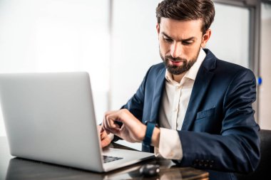 Şık bir alet kullanan ciddi bir işletme yöneticisi.