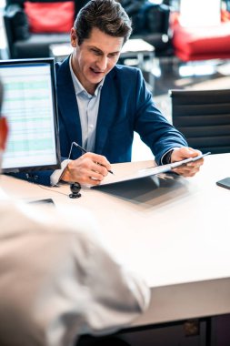 Müşteri masada bir belge imzalıyor