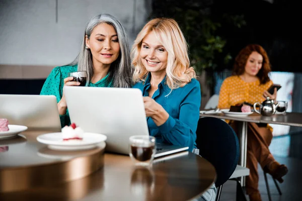 Όμορφες χαρούμενες γυναίκες που χρησιμοποιούν το laptop στο καφέ — Φωτογραφία Αρχείου