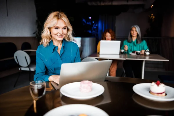 Beautiful joyful lady using laptop in cafe — Stock Photo, Image