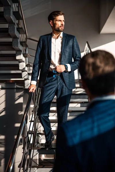 Handsome young Caucasian businessman descending the staircase — 스톡 사진