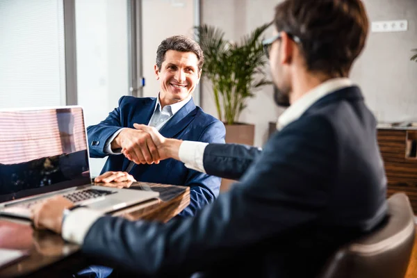 Cheerful entrepreneur shaking his business partners hand — Stock Photo, Image