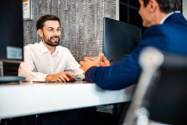 Joven gerente de oficina comunicándose con su cliente — Foto de Stock