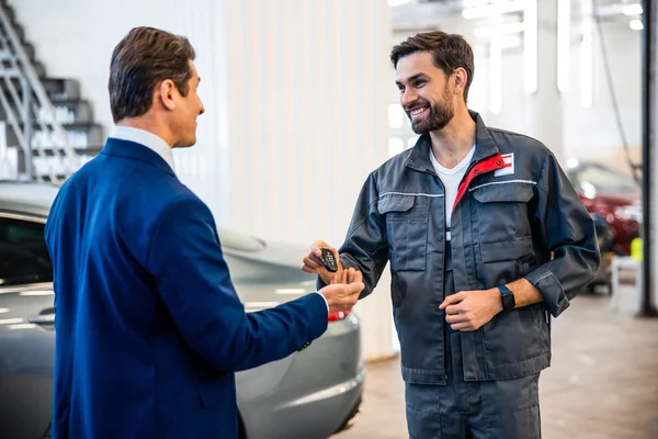 Mecânico profissional olhando para um cliente satisfeito — Fotografia de Stock
