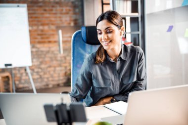 Gülümsediğini gösteren neşeli genç bir ofis çalışanı.