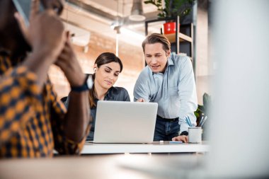 Ön planda oturan meşgul uluslararası işçi.