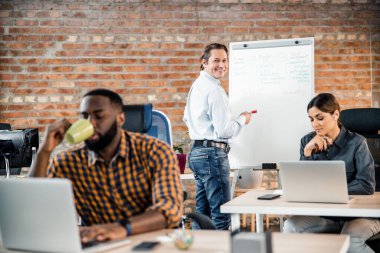 Neşeli orta yaşlı adam kameraya bakıyor.