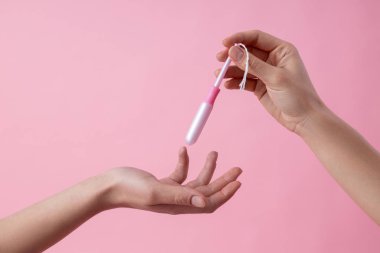 Hands of women passing tampon to each other stock photo