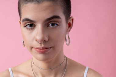 Serious girl with earrings and nose piercing stock photo