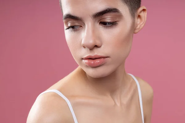 Pensive young short haired woman looking down stock photo — 스톡 사진