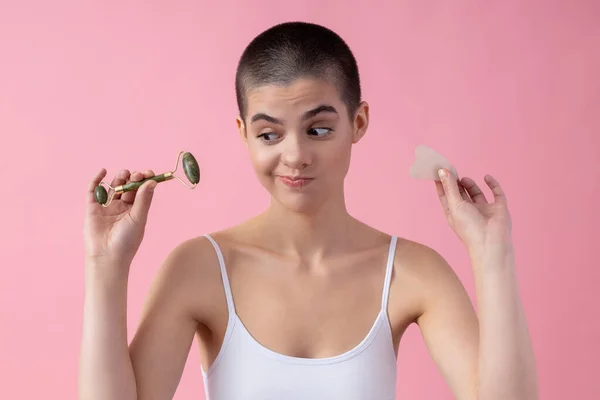 Funny lady choosing Gua Sha tool for herself stock photo — 스톡 사진