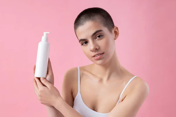 Calm young girl with white dispenser bottle stock photo — Stockfoto