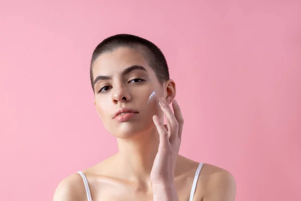 Señora de pelo corto calma usando loción facial stock foto —  Fotos de Stock