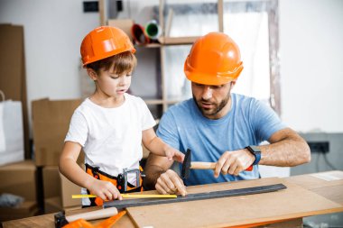 Little boy doing hammering with dad stock photo