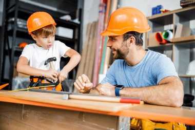 Cheerful father with kid in workshop stock photo