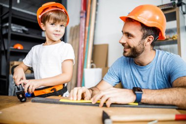 Happy boy using instruments with dad stock photo