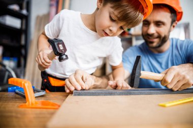 Little boy trying hammering with dad stock photo