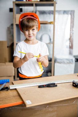 Cheeful boy in helmet with instruments stock photo