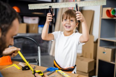 Happy boy with father in workshop stock photo