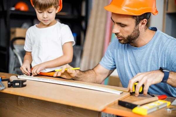 Father and son doing measurements in workshop stock photo — 图库照片