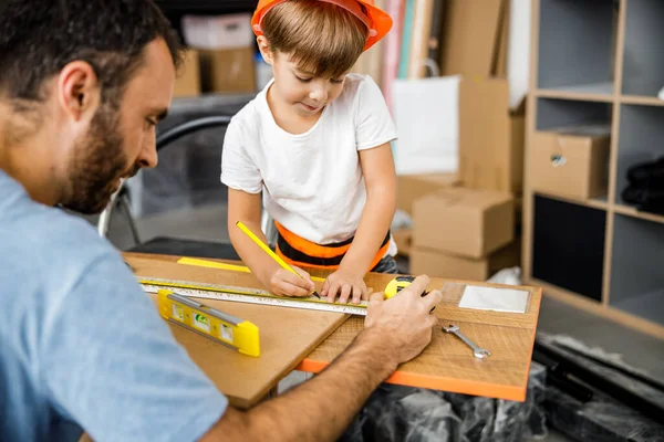 Anak kecil dengan ayah mengukur meja kayu stok foto — Stok Foto