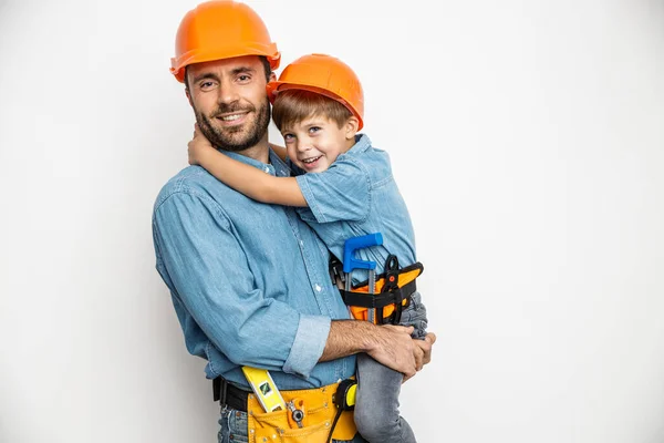 Joyful handyman embracing with son stock photo