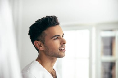 Smiling young male is posing at home