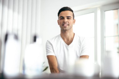 Happy young man is resting at home