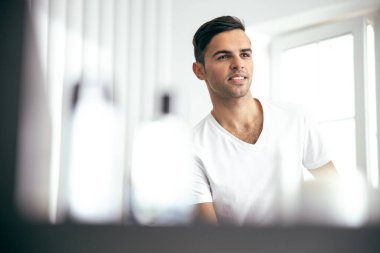 Smiling young man is resting at home