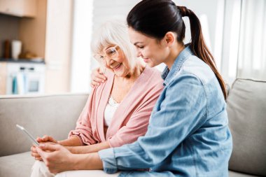 Büyükanne ve torunu modern dijital tablet kullanıyorlar.
