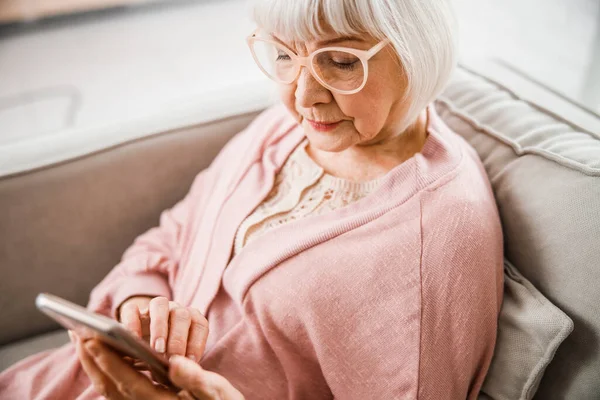 Mujer mayor en gafas con smartphone moderno — Foto de Stock