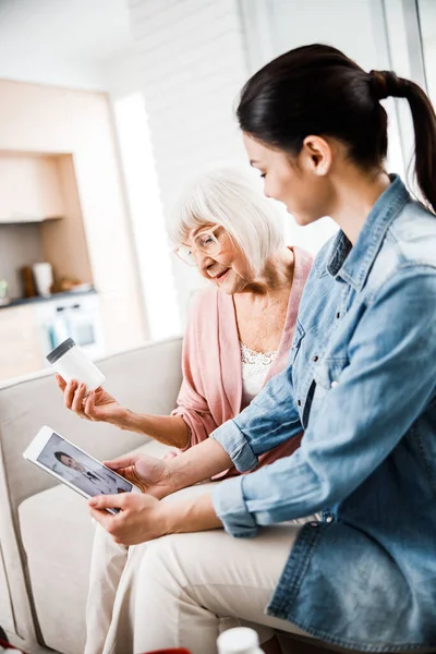 Old woman and girl talking with doctor through video call — Stock Photo, Image
