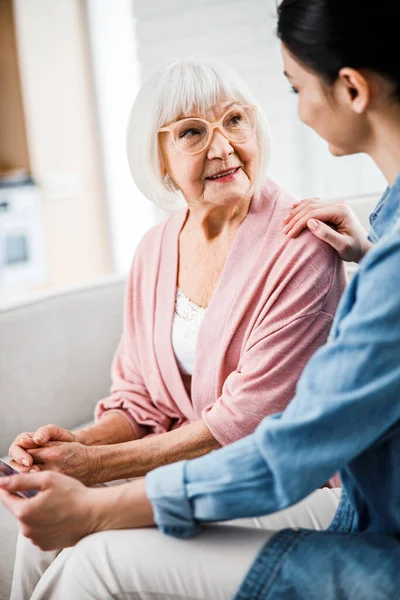 Seniorin spricht zu Hause mit Enkelin — Stockfoto